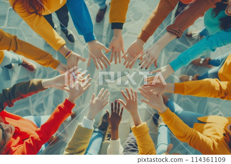 group of people standing in a circle raises their hands up 114361109