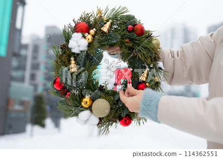 Person Holding Christmas Wreath in Snow Person Holding Christmas Wreath in Snow 114362551