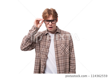 young european man with golden hair wearing glasses and a shirt looking at the camera 114362559