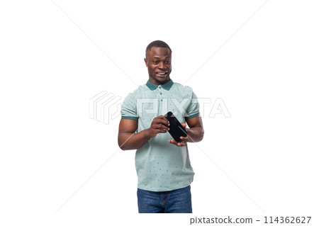 a young american guy dressed in a mint t-shirt holds a smartphone in his hand 114362627