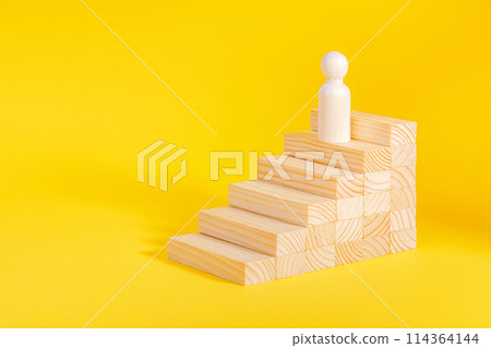 Businessman climbing stairs. Business success process, career ladder. Wooden figurine 114364144