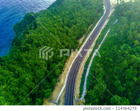 a curvy coastal road snaking along a bright blue ocean. a curvy coastal road snaking along a bright blue ocean. 114364278