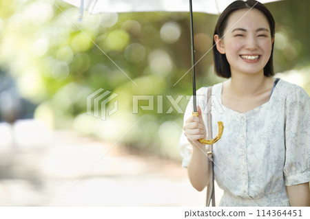 A young woman holding a parasol A young woman holding a parasol 114364451
