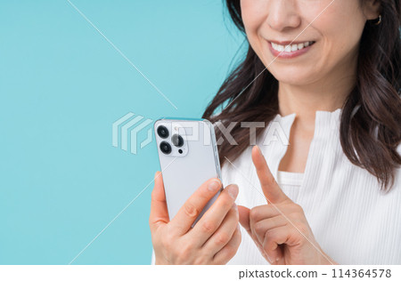 一位操作智慧型手機的中年婦女。 （部分） 114364578