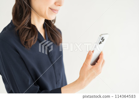 A middle-aged woman who operates a smartphone. (parts) A middle-aged woman who operates a smartphone. (parts) 114364583