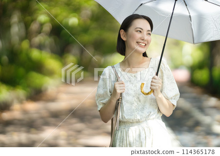 A young woman holding a parasol 114365178