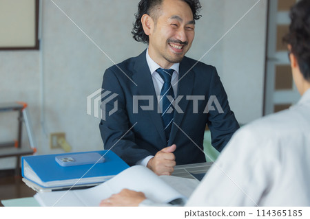 Men in suits and work clothes having a meeting 114365185