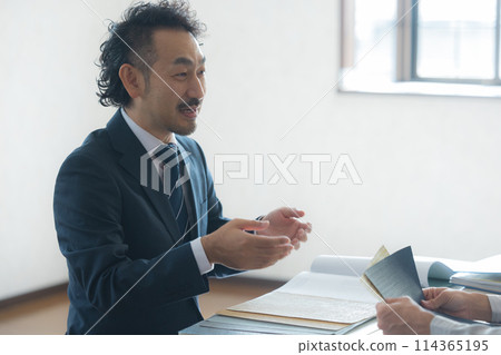 Men in suits and work clothes having a meeting Men in suits and work clothes having a meeting 114365195