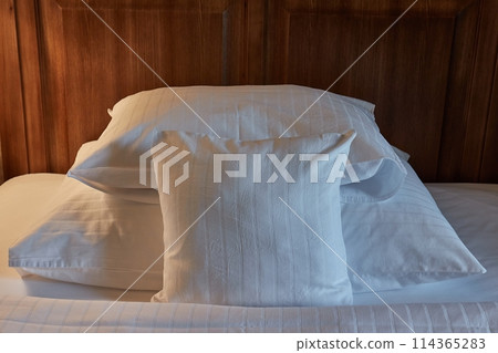Hotel bed with white sheets, cozy lighting 114365283