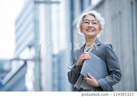 Senior woman with a PC in an office district 114365322