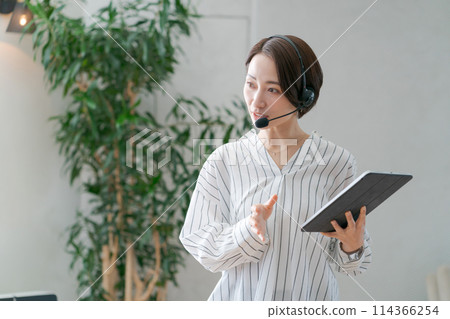 A female employee speaking with a microphone 114366254
