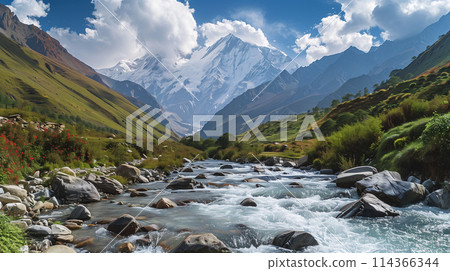 A river flows through a valley with mountains in the background. The water is crystal clear and the rocks lining the riverbed are large and jagged. The scene is serene and peaceful 114366344