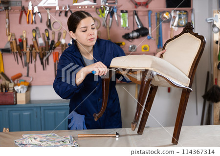 Young female furniture workshop worker designing vintage chair 114367314