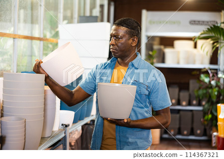 Portrait of african american man choosing pots for flowers and trees in market 114367321