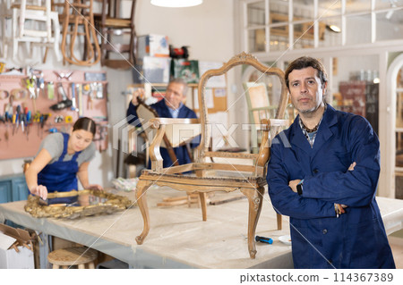 man restorer spackling antique chair surface getting piece of furniture ready for further coloring 114367389