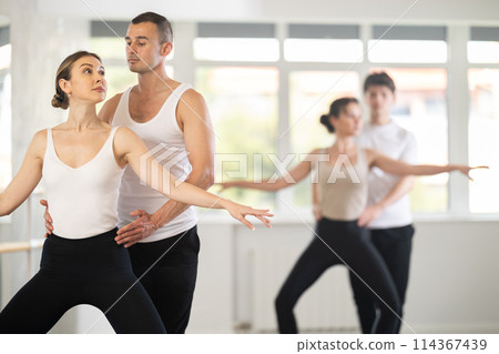 Ballet partners mastering paired technique at group class in studio Ballet partners mastering paired technique at group class in studio 114367439