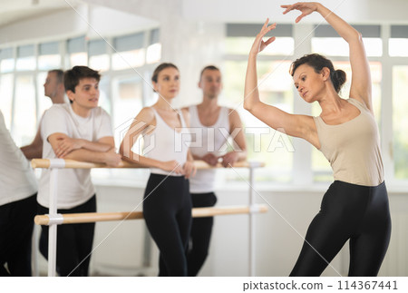 Adult woman teacher showing ballet movements Adult woman teacher showing ballet movements 114367441