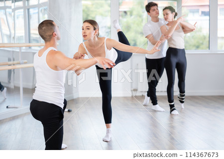 Ballet dancer providing support of female partner in challenging movements Ballet dancer providing support of female partner in challenging movements 114367673