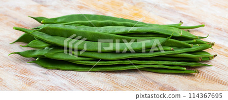 Green beans pods on a wooden surface 114367695
