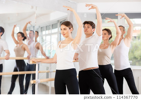 Group of dancers doing batman tandu jete at barre Group of dancers doing batman tandu jete at barre 114367770