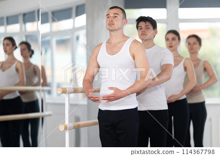Group of dancers stand in first position at barre Group of dancers stand in first position at barre 114367798