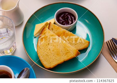 Breakfast. Croutons with cheese and jam on table 114367825