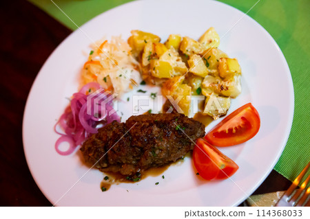 Plate with a meat dish lula-kebab and stewed potatoes. Plate with a meat dish lula-kebab and stewed potatoes. 114368033