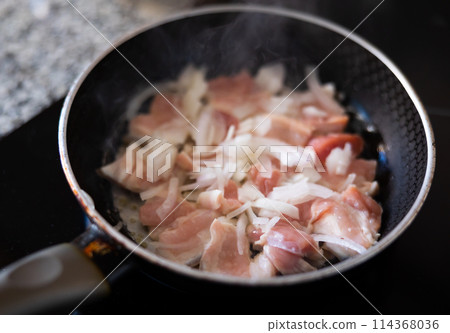 Cooking pork meat in pan with onions and spices Cooking pork meat in pan with onions and spices 114368036