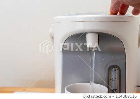 Pouring hot water from an electric kettle into a mug Pouring hot water from an electric kettle into a mug 114368116