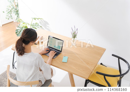 Back view of a woman working remotely Back view of a woman working remotely 114368160
