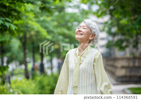 Senior woman smiling, looking up at the sky 114368591