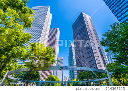 Shinjuku, Tokyo cityscape in Japan. View of Nishi-Shinjuku sign at the intersection behind Shinjuku Police Station and skyscrapers, April 28th 114368615