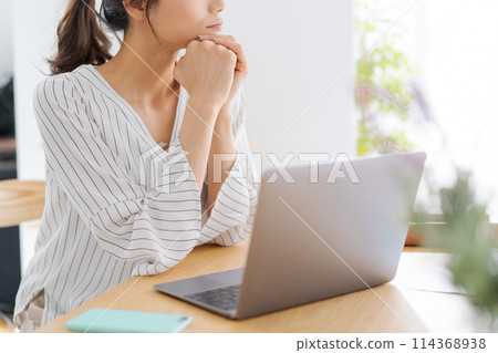 一個女人靠在下巴上看向一邊 一個女人靠在下巴上看向一邊 114368938