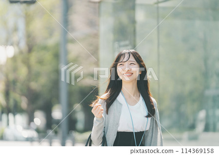 A woman in her 20s with a cute smile walking through the city A woman in her 20s with a cute smile walking through the city 114369158