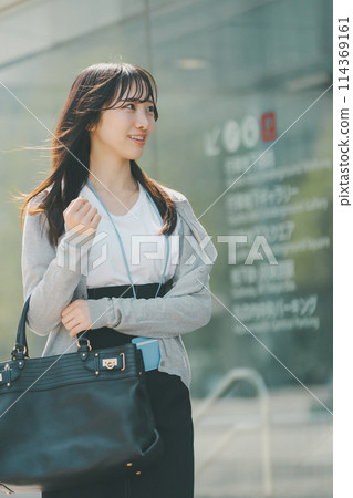 A woman in her 20s with a cute smile walking through the city A woman in her 20s with a cute smile walking through the city 114369161