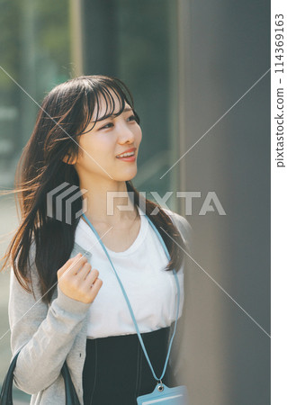 A woman in her 20s with a cute smile walking through the city A woman in her 20s with a cute smile walking through the city 114369163