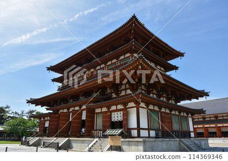 Yakushiji temple's main hall shines against the blue sky 114369346