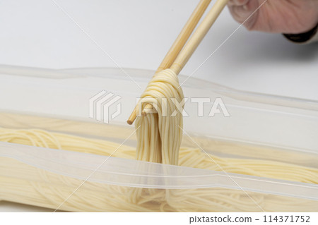 Water-soaked pasta, lifted with chopsticks Water-soaked pasta, lifted with chopsticks 114371752