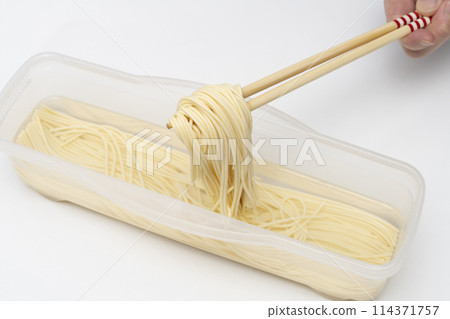 Water-soaked pasta, lifted with chopsticks 114371757