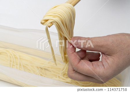 Water-soaked pasta, lifted with chopsticks 114371758