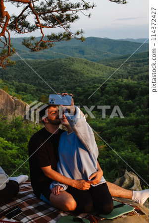 happy couple having date at the cliff on sunset 114372427