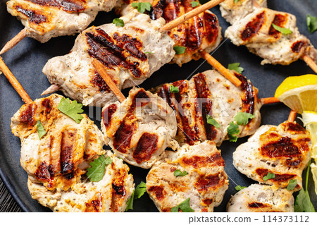 grilled mini pork skewers on a plate, top view grilled mini pork skewers on a plate, top view 114373112