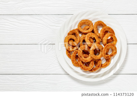 deep fried crispy onion rings on white plate 114373120