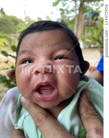 Newborn baby girl looking at camera with open mouth and tongue out 114373459
