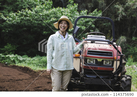 拖拉機和站在田野前的女人 114375690