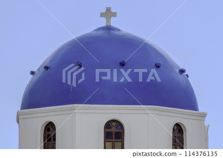 Greece, Santorini, Oia, Orthodox cross on a blue dome with blue sky 114376135