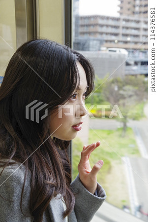 Young woman looking out the window of a train in the city Young woman looking out the window of a train in the city 114376581