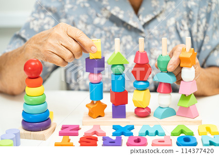 Alzheimer disease AD, Asian elderly woman patient suffering from dementia learn practical motor skills rehabilitation. Alzheimer disease AD, Asian elderly woman patient suffering from dementia learn practical motor skills rehabilitation. 114377420
