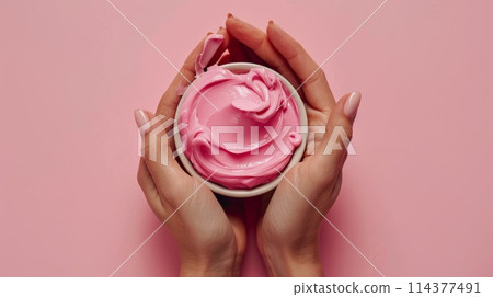 Woman's Hands Holding Bowl of Pink Moisturizing Cream on Pastel Background Woman's Hands Holding Bowl of Pink Moisturizing Cream on Pastel Background 114377491
