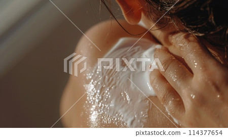 Woman Applying Sunscreen on Shoulder Under Sunlight 114377654